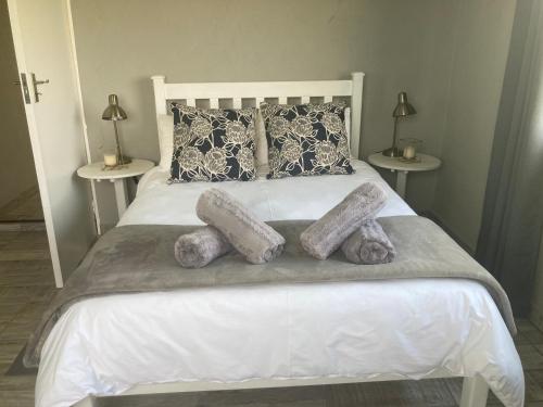- un lit blanc avec 2 oreillers et des serviettes dans l'établissement Mountain View Farm Cottage 4X4 Vehicles ONLY, à Dullstroom