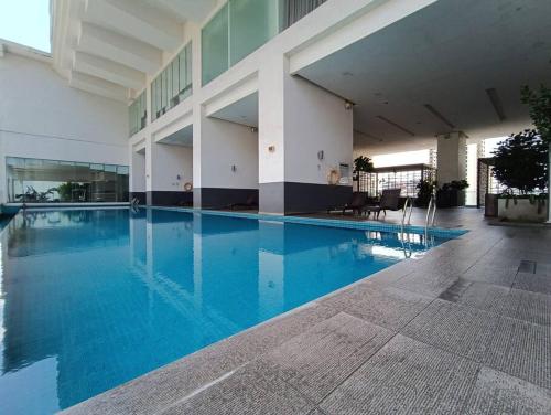 a large swimming pool in a building with blue water at RM201 Bukit Bintang 2 Bedroom Balcony CIty View in Kuala Lumpur