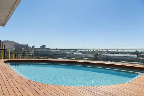uma grande piscina azul num deque de madeira em Modern Studio in Wex1 538 em Cidade do Cabo