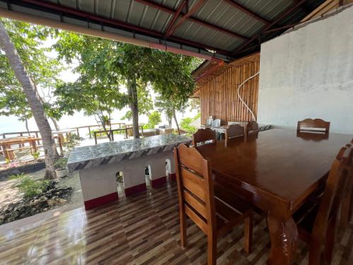 a dining room with a wooden table and chairs at Gratum Beach Resort in Dapitan