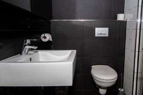 La salle de bains est pourvue d'un lavabo blanc et de toilettes. dans l'établissement Modern Studio in Wex1 538, au Cap