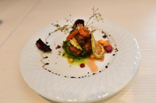 a white plate with a dish of food on a table at LE PALME HOTEL in Oran