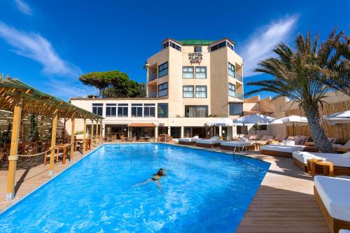 a person swimming in a pool in front of a hotel at Hotel Playa Sur Tenerife in El Médano