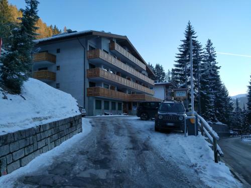 a parking lot in front of a building in the snow at Monolocale a 150m da impianto di risalita Spinale CIPAT O22247-AT-O11471 in Madonna di Campiglio