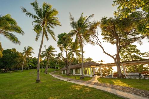 a house in the middle of a field with palm trees at Ban Raya Resort and Spa in Ko Racha Yai