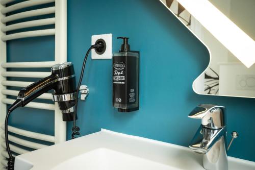 a hair dryer on a wall above a sink at Ibis Budget Strasbourg Centre Gare in Strasbourg