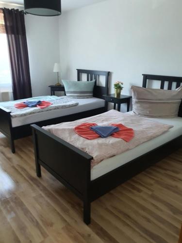twee bedden in een kamer met rode shirts erop bij Mimalou möbliertes Apartment in Zwickau in Zwickau