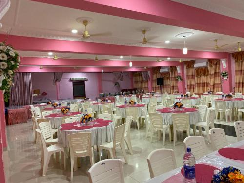 a banquet hall with white tables and white chairs at Hotel Juli Reception in Mannar