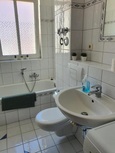 een witte badkamer met een wastafel en een toilet bij Mimalou möbliertes Apartment in Zwickau in Zwickau