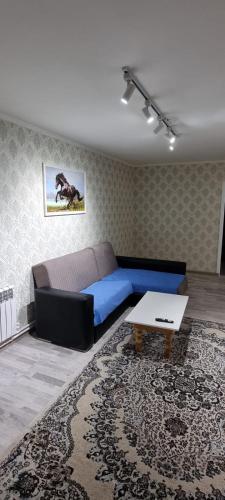 Sala de estar con cama azul y mesa en 2-комнатная квартира, 55 м², 2/5 этаж посуточно, 8-й микрорайон, 8-й микрорайон 16, en Shymkent