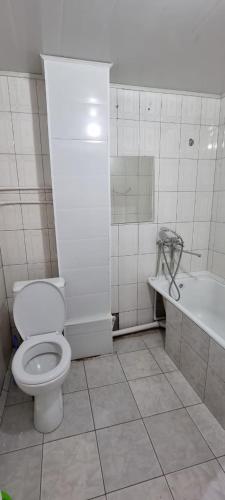 y baño con aseo y bañera. en 2-комнатная квартира, 55 м², 2/5 этаж посуточно, 8-й микрорайон, 8-й микрорайон 16, en Shymkent