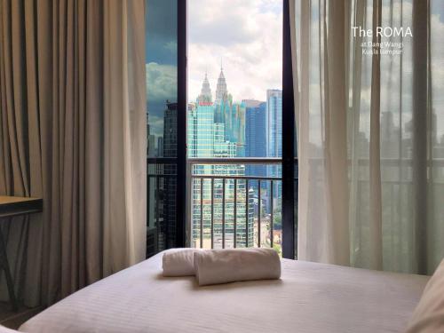 ein Hotelzimmer mit einem Bett und einem großen Fenster in der Unterkunft The Roma at Dang Wangi Kuala Lumpur in Kuala Lumpur