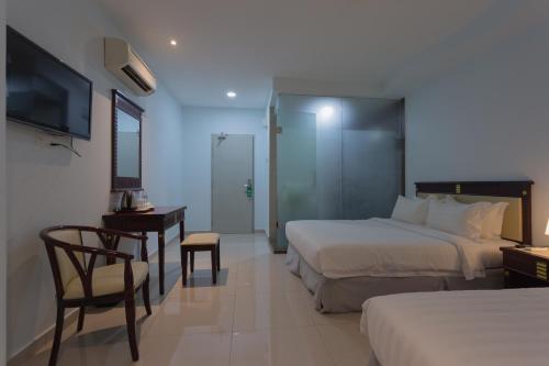 Pokój hotelowy z 2 łóżkami, biurkiem i telewizorem w obiekcie Al Amin Muslim Friendly Hotel w Kuala Lumpur