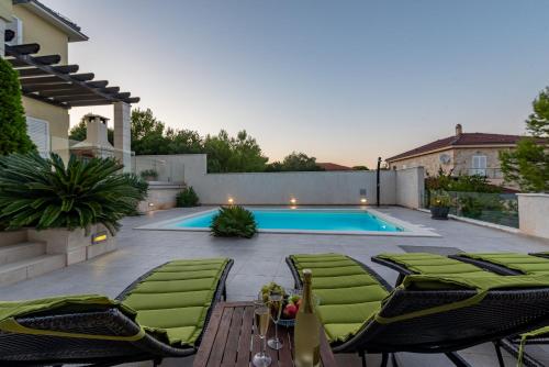 a patio with chairs and a swimming pool at Villa Tatijana ZadarVillas in Kukljica