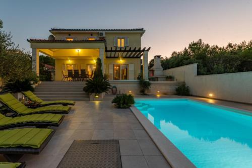 a backyard with a swimming pool and a house at Villa Tatijana ZadarVillas in Kukljica
