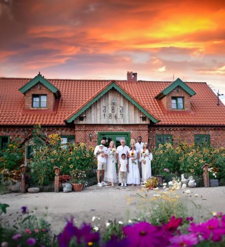 a group of people standing in front of a building at Osada Między Drzewami in Braniewo