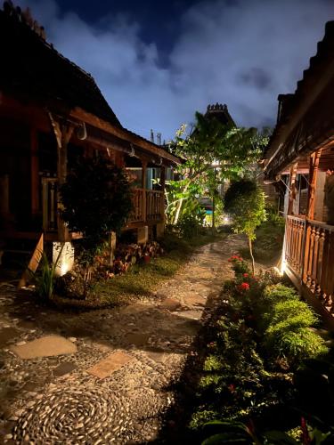 a street in a village with houses and flowers at PINOKKIO B&B Restaurant in Jimbaran