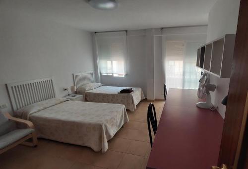 um quarto de hotel com duas camas e uma mesa em Residencia Universitaria Reuniver Burjassot em Benimamet