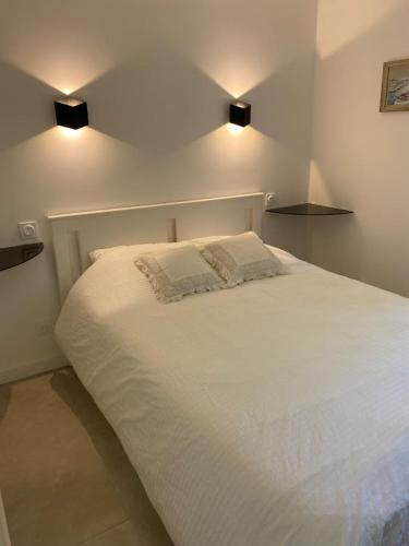 un lit blanc avec deux oreillers dessus dans l'établissement Appartement T2 Sainte Maxime, à Sainte-Maxime