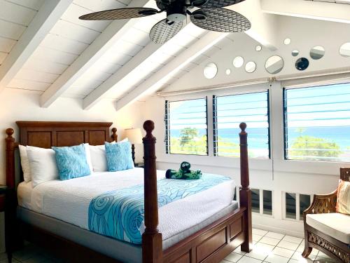 Big Island Retreat في كيلوا كونا: غرفة نوم مع سرير ومروحة سقف