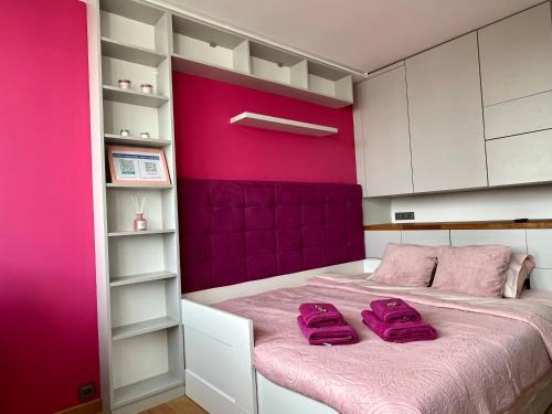 um quarto com uma parede rosa e uma cama em -- View City Center Pink -- em Varsóvia