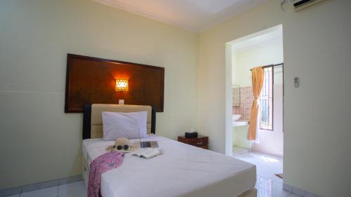 Un pat sau paturi într-o cameră la Teges Inn Kuta