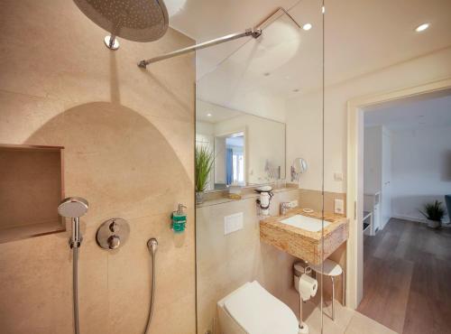 ein Bad mit einer Dusche, einem WC und einem Waschbecken in der Unterkunft Fitschen am Dorfteich in Wenningstedt-Braderup