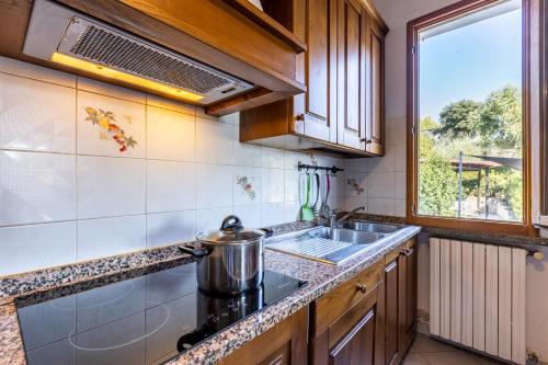 a kitchen with a stove and a sink and a window at Sole Verde green house in Terricciola
