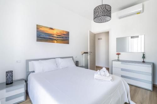 a white bedroom with a white bed and a painting on the wall at DomusMi Benedetto Marcello-28 in Milan
