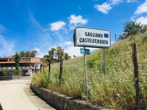 um sinal de rua no lado de uma estrada em ORO VERDE Apartments em Gagliano Castelferrato