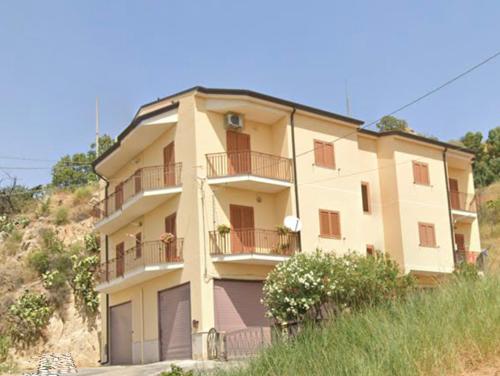 um grande edifício com varandas no topo de uma colina em ORO VERDE Apartments em Gagliano Castelferrato