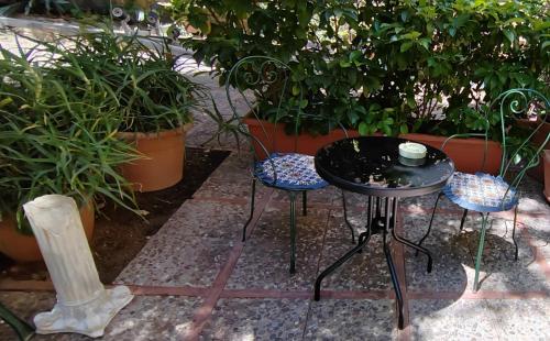 a black table and two chairs and some plants at Room in Villa Galletti Inguaggiato in Bagheria