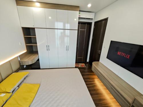 a bedroom with a bed and a flat screen tv at Ấm cúng, hiện đại, tiện nghi! in Hai Phong