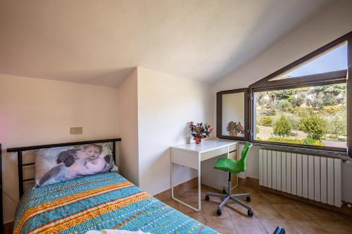 a bedroom with a bed and a desk and a window at Sole Verde green house in Terricciola