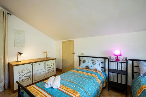 a bedroom with a bed and a dresser and a lamp at Sole Verde green house in Terricciola