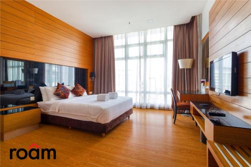 um quarto de hotel com uma cama e uma televisão de ecrã plano em Dua Sentral Kuala Lumpur by Roam em Kuala Lumpur