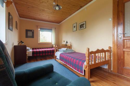 a small bedroom with two beds and a couch at Viesu māja Vanaturs in Roja