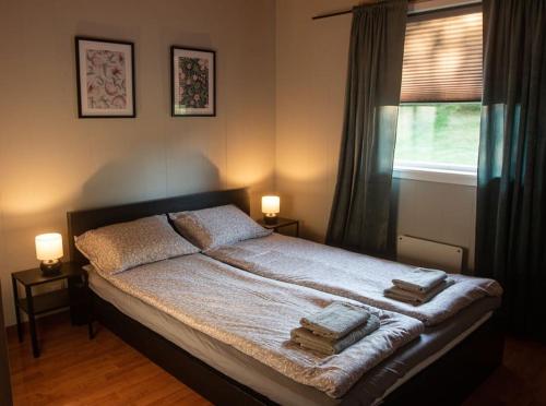 1 dormitorio con 1 cama con 2 lámparas y una ventana en Apartment-A near Etne-Odda, en Etnesjøen