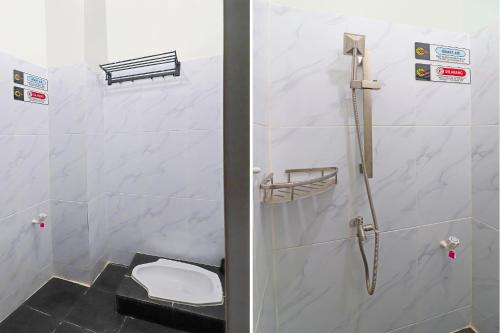 a bathroom with a shower with a toilet in it at OYO Life 92691 Mc Kost Syariah in Jambi