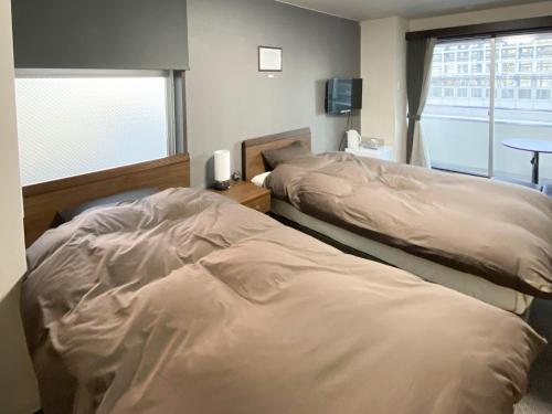 - 2 lits installés l'un à côté de l'autre dans une chambre dans l'établissement Kamuy Rera, à Kushiro