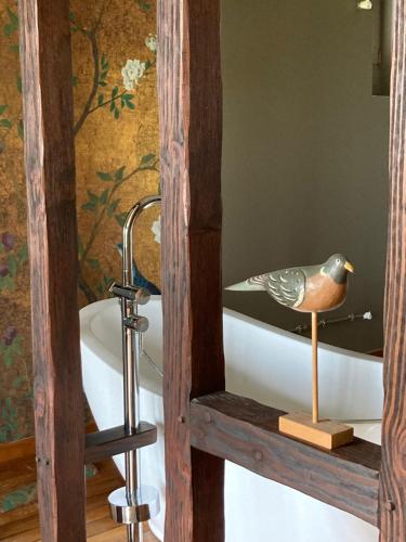 a bird sitting on a bath tub in a bathroom at le secret du chat in Cordes-sur-Ciel