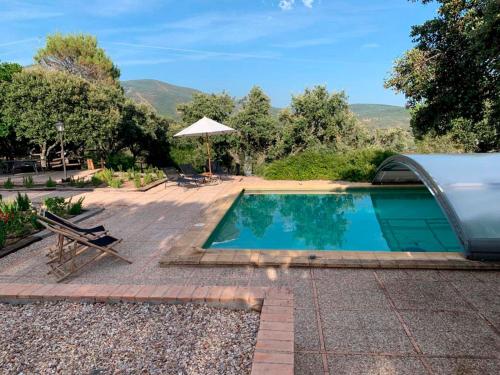 a swimming pool with a table and an umbrella at Casa Rural La Joyona in Los Navalucillos