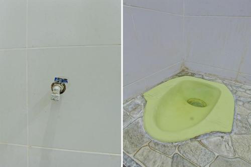 a bathroom with a green toilet in a tiled floor at OYO Life 93058 Kos Subur in Tanjung