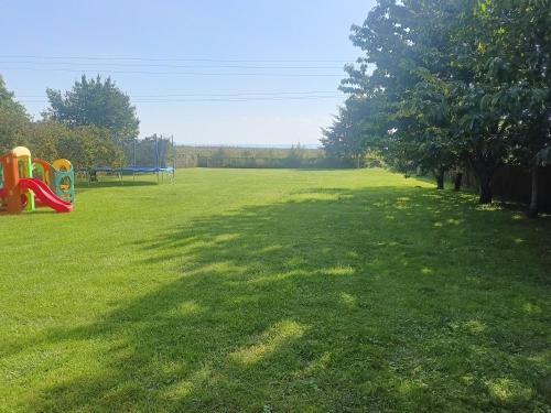 a large grassy field with a park with a playground at Kraken-pokoje gościnne in Krynica Morska