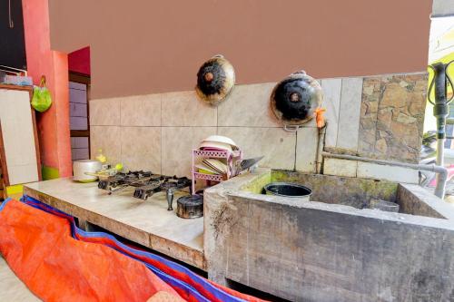 een keuken met een fornuis en enkele potten en pannen bij OYO Life 92840 Wisma Morricco in Jombang