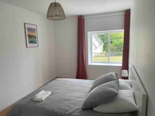 een bed in een slaapkamer met een raam bij Maison 6 chambres in Clohars-Carnoët