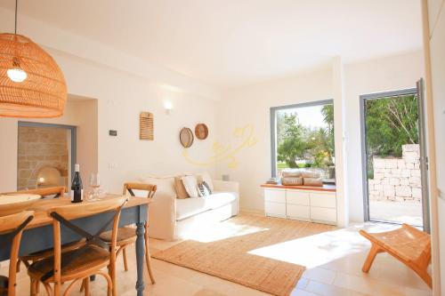 a living room with a table and a couch at TD Trulli Tortorella with Nature Pool Sauna in Monopoli