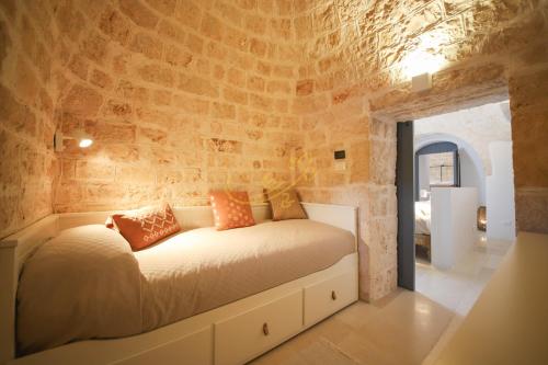 ein Schlafzimmer mit einem Bett in einer Steinmauer in der Unterkunft Trulli Dimore - Tortorella in Monopoli
