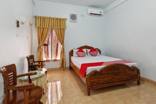 - une chambre avec un lit, une table et des chaises dans l'établissement OYO Life 92803 Penginapan Purnama, à Kayuagung