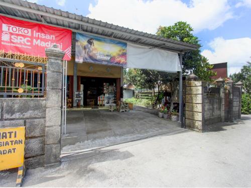 un frente de tienda con una pancarta roja delante de ella en OYO Life 92829 Kos Insan Madani, en Praya